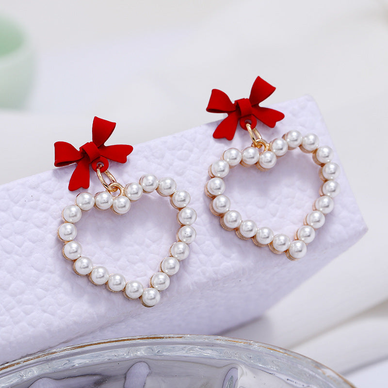 Wholesale Pearl Hollow Heart Shaped Pendant Bow Alloy Earrings