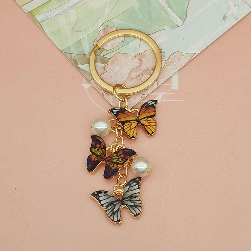 Keychains de metal de perlas de imitación de mariposa de aceite de aceite de color al tanto