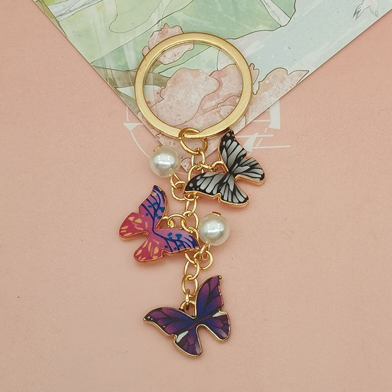 Keychains de metal de perlas de imitación de mariposa de aceite de aceite de color al tanto