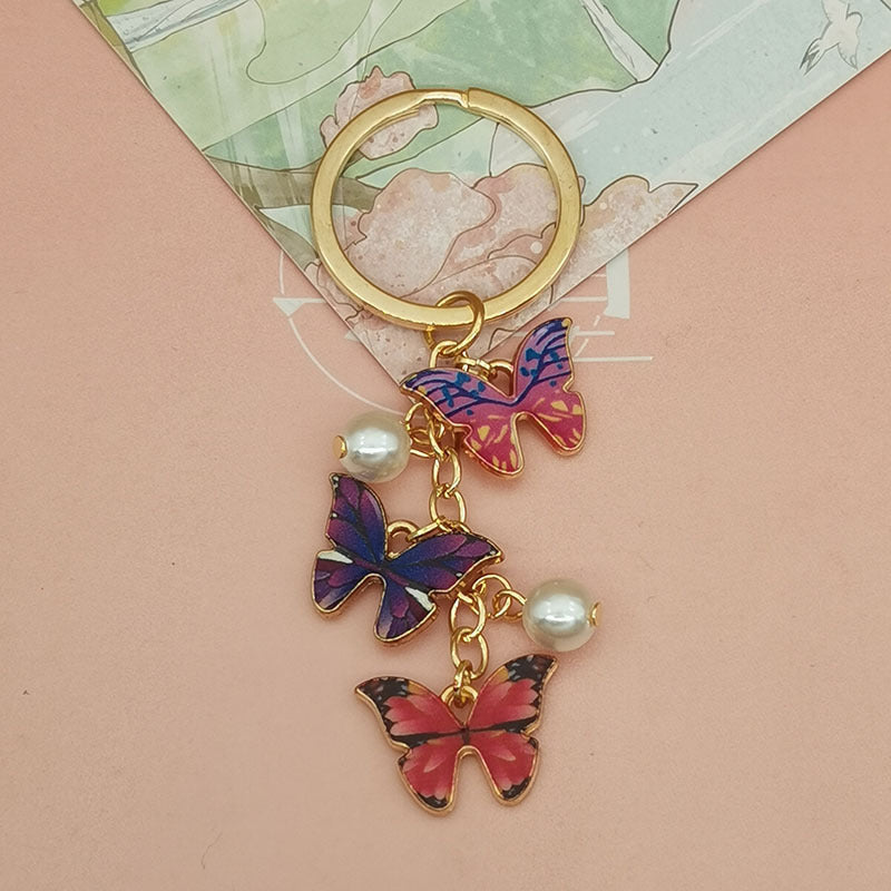 Keychains de metal de perlas de imitación de mariposa de aceite de aceite de color al tanto