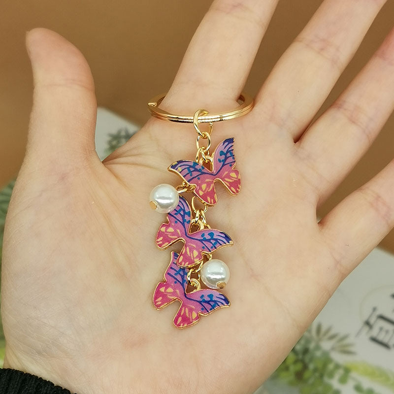 Keychains de metal de perlas de imitación de mariposa de aceite de aceite de color al tanto