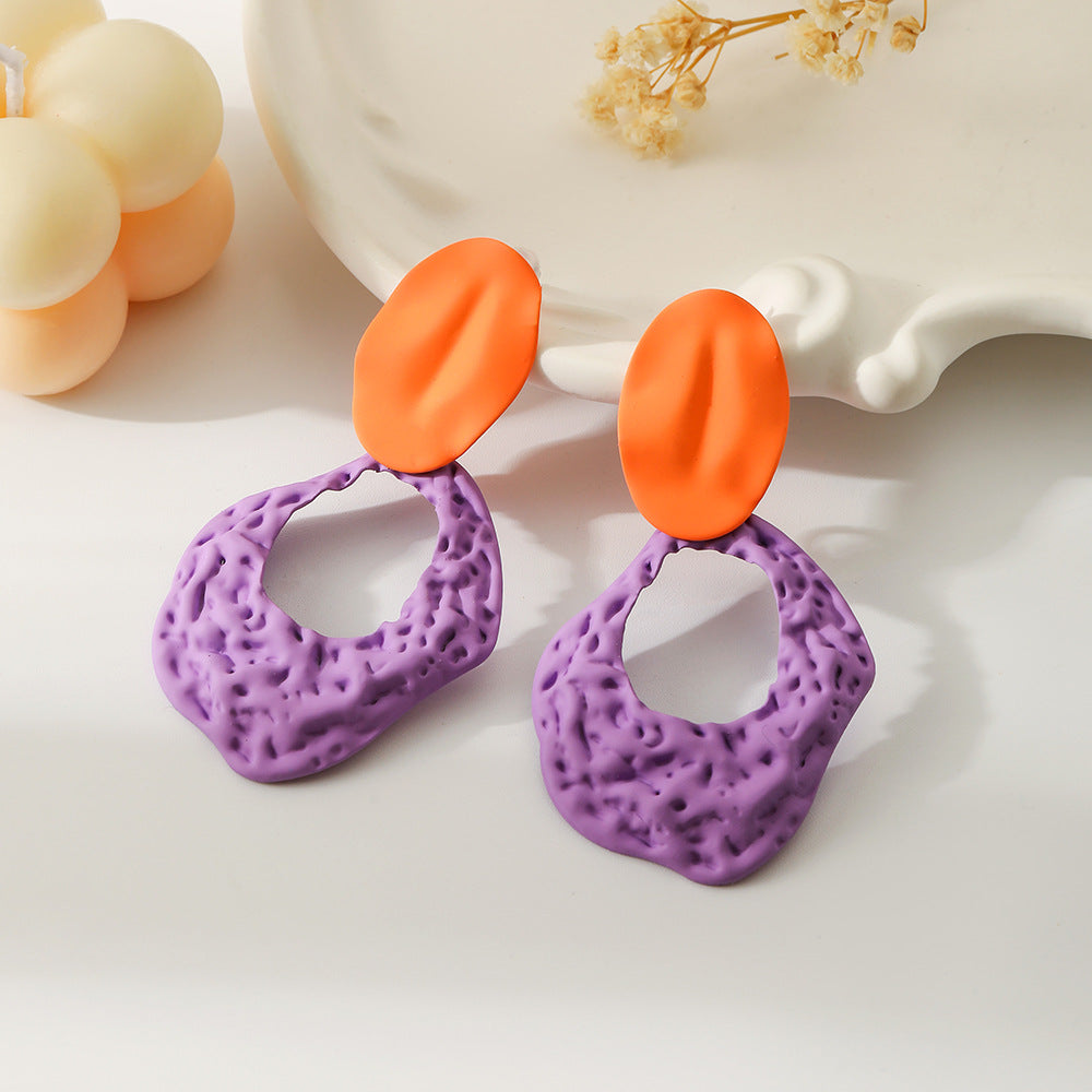 Color al por mayor Spray pintada Elipse Hollow Out Rock Texture Metal Pendientes