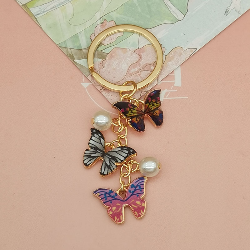 Keychains de metal de perlas de imitación de mariposa de aceite de aceite de color al tanto