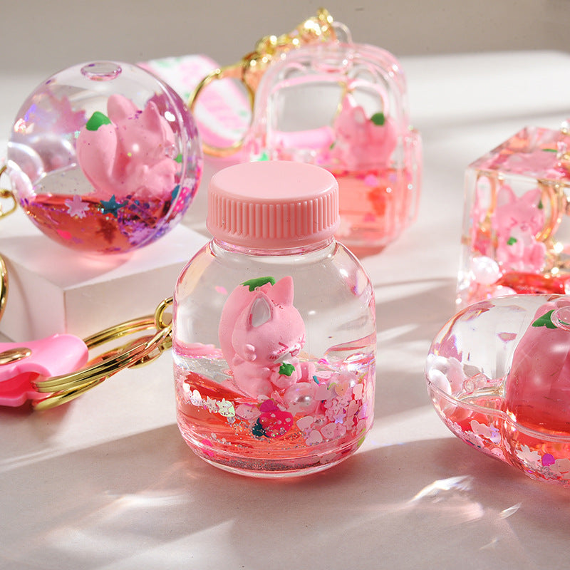 Acrílico al por mayor en la cadena de llave de botella de arena de la logística del flotador de aceite