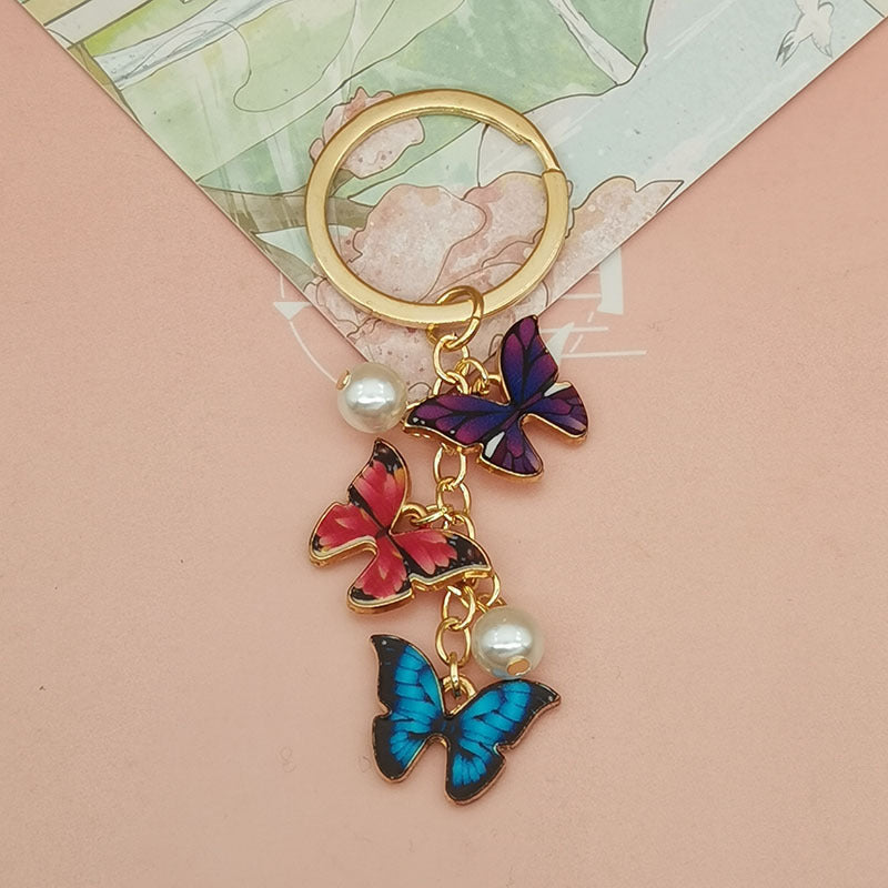 Keychains de metal de perlas de imitación de mariposa de aceite de aceite de color al tanto