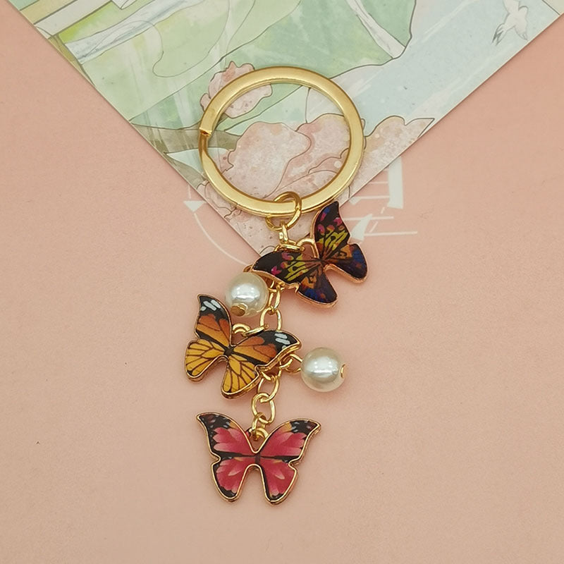 Keychains de metal de perlas de imitación de mariposa de aceite de aceite de color al tanto