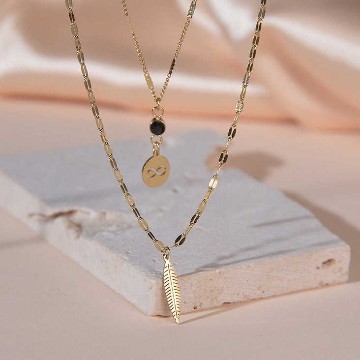 Venta al por mayor de acero inoxidable símbolo inalámbrico pluma diamante negro collar de doble capa