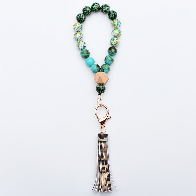 Comercio al por mayor de cuentas de madera PU impreso borla colgante muñeca llavero