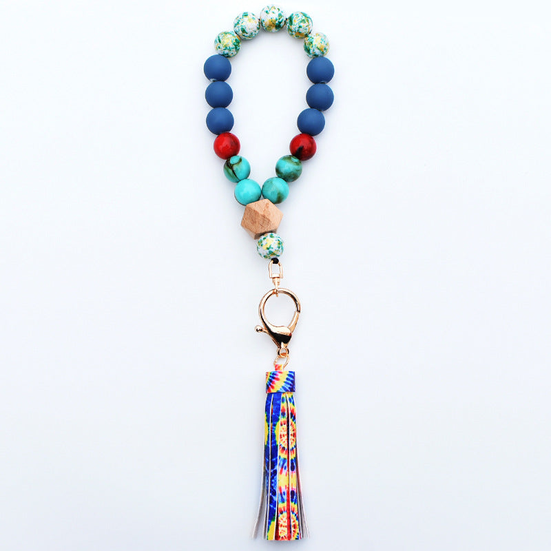Comercio al por mayor de cuentas de madera PU impreso borla colgante muñeca llavero