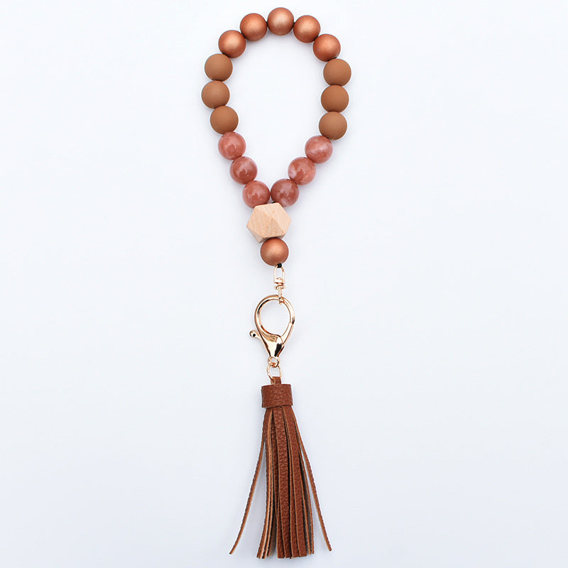 Comercio al por mayor de cuentas de madera PU impreso borla colgante muñeca llavero