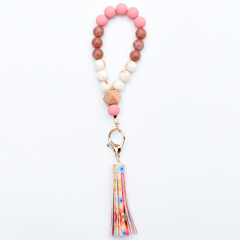 Comercio al por mayor de cuentas de madera PU impreso borla colgante muñeca llavero