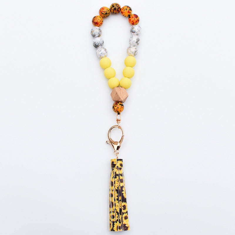 Comercio al por mayor de cuentas de madera PU impreso borla colgante muñeca llavero