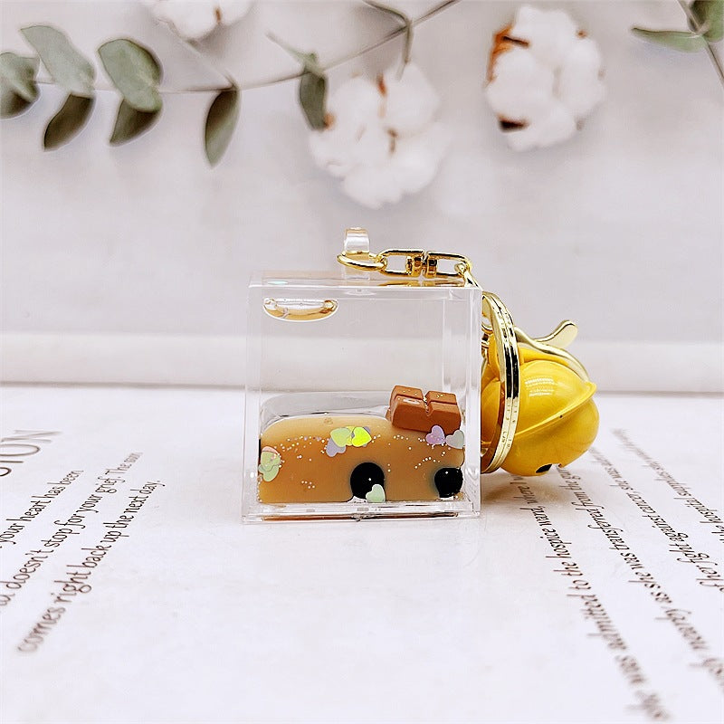 Comercio al por mayor acrílico flotando en el aceite de chocolate arenas movedizas llavero creativo