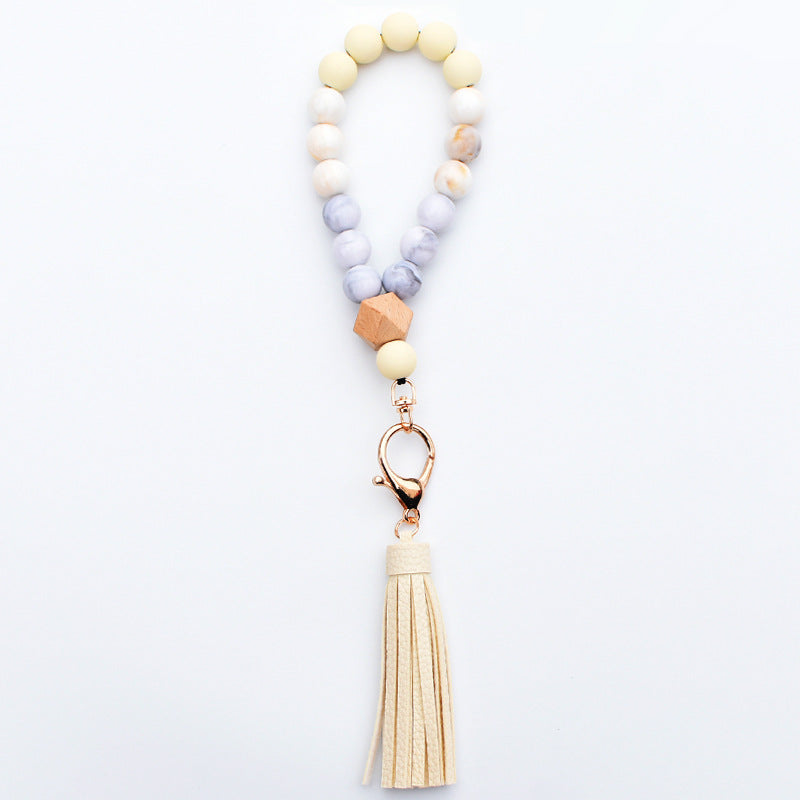 Comercio al por mayor de cuentas de madera PU impreso borla colgante muñeca llavero