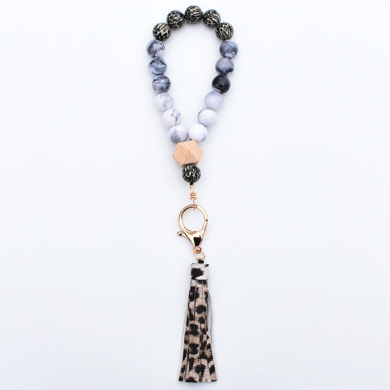 Comercio al por mayor de cuentas de madera PU impreso borla colgante muñeca llavero