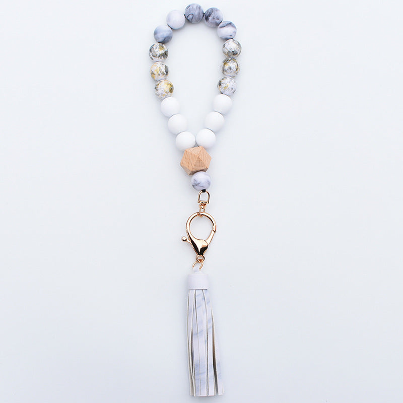 Comercio al por mayor de cuentas de madera PU impreso borla colgante muñeca llavero